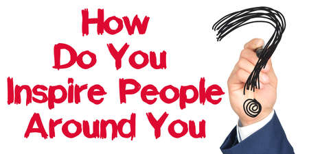 Hand with marker writing: How Do You Inspire People Around You. Hand of a businessman with a marker.の写真素材