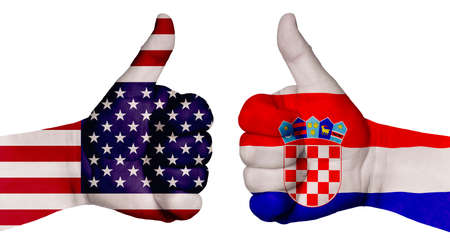The concept of strengthening the relationship of nations. Two hands are painted with flags of different countries, with a thumb raised up. Croatia and the USAの写真素材