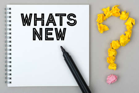 Hand with marker writing: Whats New. Notepad and question mark.の写真素材