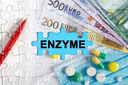 Double exposure. Puzzles with the image of pills, medical mask, pens and euro with the inscription -ENZYME. The concept of medicine.の写真素材