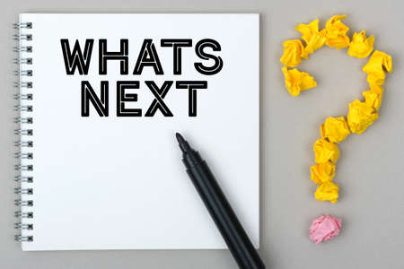 Hand with marker writing: Whats Next. Notepad and question mark.の写真素材