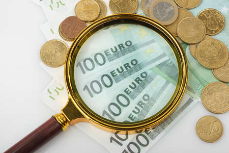 hand magnifier over euro banknote isolated on white background. Financial conceptの写真素材