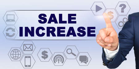 Business concept. Businessman touching virtual screen with his finger. Screen caption - SALE INCREASEの写真素材