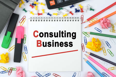 Business concept. On the table is a calculator, diary, markers, pencils and a notebook with the inscription - Consulting Businessの写真素材