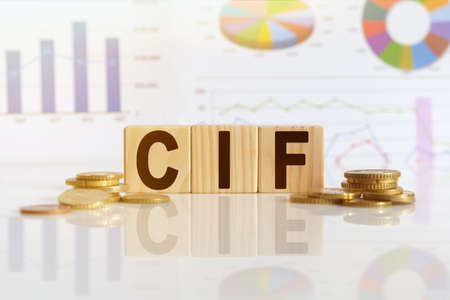 Cost Insurance Freight. CIF the word on wooden cubes, cubes stand on a reflective surface, in the background is a business diagram. Business and finance conceptの写真素材
