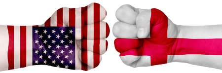 The concept of the struggle of peoples. Two hands are clenched into fists and are located opposite each other. Hands painted in the colors of the flags of the countries. England vs USAの写真素材