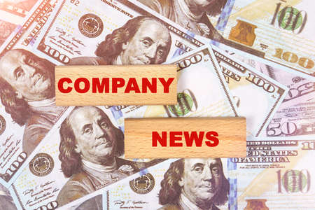 Business concept. Against the background of dollar bills, the text is written on wooden blocks - company newsの写真素材
