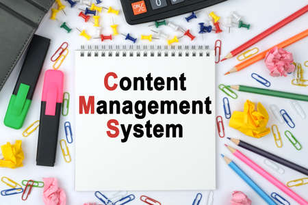 Business concept. On the table is a calculator, diary, markers, pencils and a notebook with the inscription - Content Management Systemの写真素材