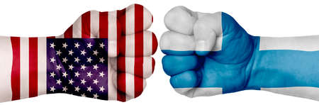 The concept of the struggle of peoples. Two hands are clenched into fists and are located opposite each other. Hands painted in the colors of the flags of the countries. Finland vs USAの写真素材