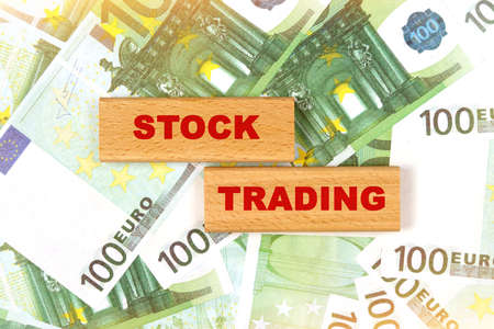Business concept. Against the background of euro bills, the text is written on wooden blocks - stock tradingの写真素材