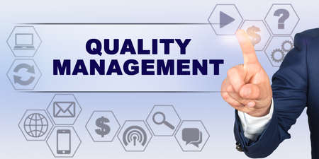 Business concept. Businessman touching virtual screen with his finger. Screen caption - QUALITY MANAGEMENTの写真素材
