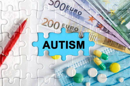 Double exposure. Puzzles with the image of pills, medical mask, pens and euro with the inscription -AUTISM. The concept of medicine.の写真素材