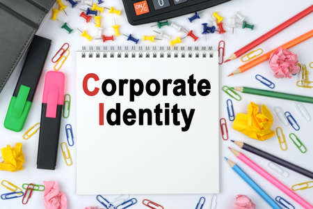 Business concept. On the table is a calculator, diary, markers, pencils and a notebook with the inscription - Corporate Identityの写真素材