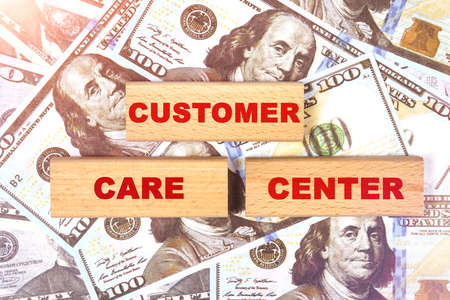 Business concept. Against the background of dollar bills, the text is written on wooden blocks - customer care centerの写真素材