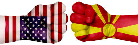 The concept of the struggle of peoples. Two hands are clenched into fists and are located opposite each other. Hands painted in the colors of the flags of the countries. Macedonia vs USAの写真素材