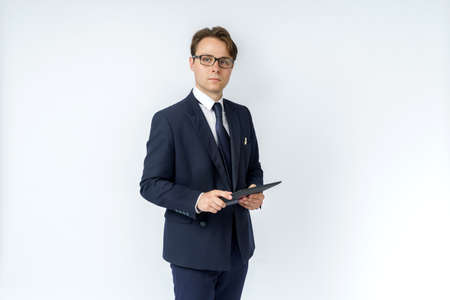 Portrait of a businessman in a blue suit holding an electronic tablet on a white background. No face visible. Business and finance conceptの写真素材