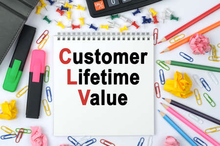 Business concept. On the table is a calculator, diary, markers, pencils and a notebook with the inscription - Customer Lifetime Valueの写真素材