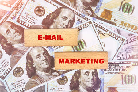 Business concept. Against the background of dollar bills, the text is written on wooden blocks - email marketingの写真素材