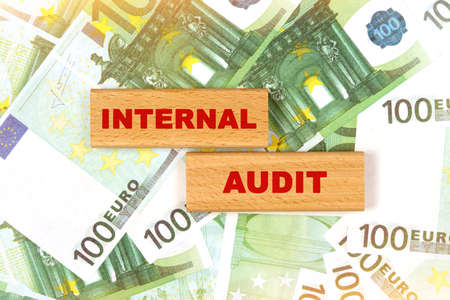 Business concept. Against the background of euro bills, the text is written on wooden blocks - internal auditの写真素材