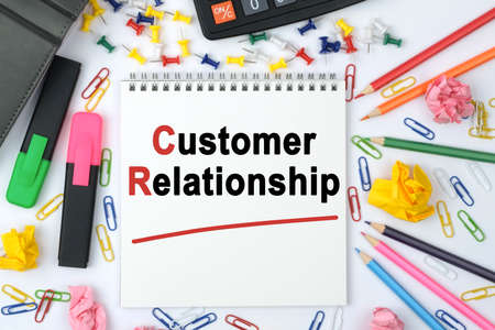 Business concept. On the table is a calculator, diary, markers, pencils and a notebook with the inscription - Customer Relationshipの写真素材
