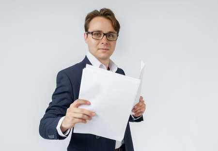 Businessman with scattered papers. Business, people, emotions - businessman throws documents in the office. Business and finance concept.の写真素材