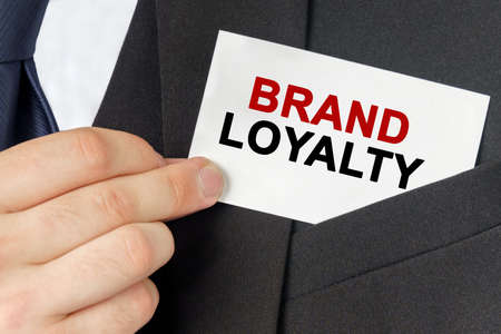 Business concept. Businessman holds a card with the text - BRAND LOYALTYの写真素材