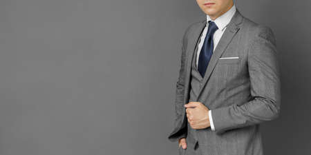 Portrait of a businessman in a suit. No face visible. Gray background. Business and finance conceptの写真素材