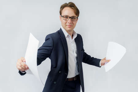 Businessman with scattered papers. Business, people, emotions - businessman throws documents in the office. Business and finance concept.の写真素材