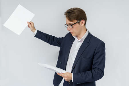 Businessman with scattered papers. Business, people, emotions - businessman throws documents in the office. Business and finance concept.の写真素材
