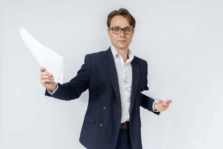 Businessman with scattered papers. Business, people, emotions - businessman throws documents in the office. Business and finance concept.の写真素材