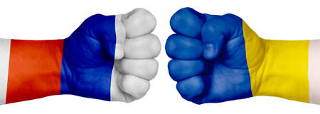 The concept of the struggle of peoples. Two hands are clenched into fists and are located opposite each other. Hands painted in the colors of the flags of the countries. Russia vs Ukraineの写真素材