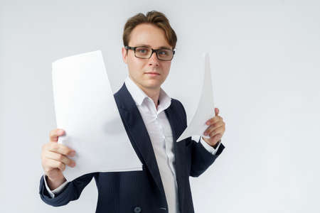 Businessman with scattered papers. Business, people, emotions - businessman throws documents in the office. Business and finance concept.の写真素材