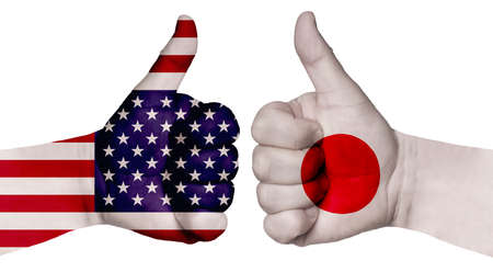 The concept of strengthening the relationship of nations. Two hands are painted with flags of different countries, with a thumb raised up. Japan and the USAの写真素材