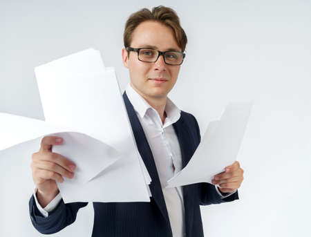 Businessman with scattered papers. Business, people, emotions - businessman throws documents in the office. Business and finance concept.の写真素材