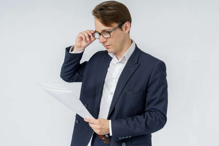 Businessman with scattered papers. Business, people, emotions - businessman throws documents in the office. Business and finance concept.の写真素材
