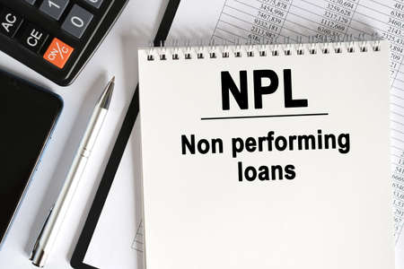 On the table lies a smartphone, a calculator and a notebook with the inscription- NPL. Non performing loans. Business conceptの写真素材
