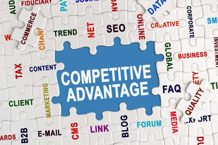 Economy and business concept. Puzzle with economic captions, in the center the inscription - COMPETITIVE ADVANTAGEの写真素材