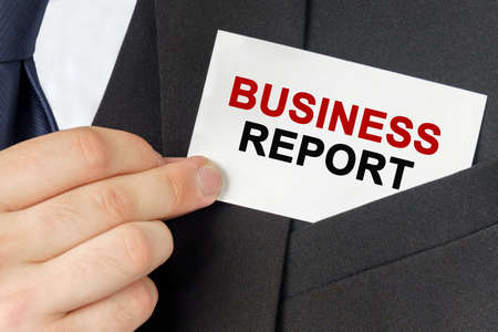 Business concept. Businessman holds a card with the text - BUSINESS REPORTの写真素材