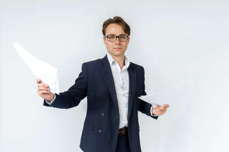 Businessman with scattered papers. Business, people, emotions - businessman throws documents in the office. Business and finance concept.の写真素材