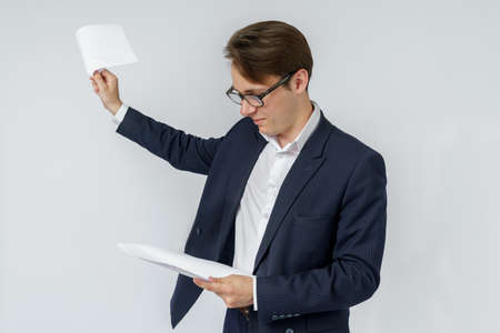 Businessman with scattered papers. Business, people, emotions - businessman throws documents in the office. Business and finance concept.の写真素材