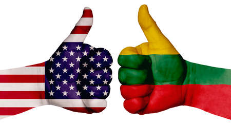 The concept of strengthening the relationship of nations. Two hands are painted with flags of different countries, with a thumb raised up. Lithuania and the USAの写真素材