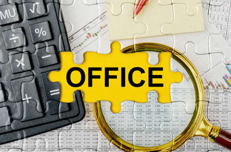 Business concept. Puzzle with a calculator, magnifying glasses and financial documents in the center inscription -OFFICEの写真素材