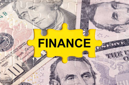 Business concept. Puzzle with the image of dollars in the center of the inscription -FINANCEの写真素材