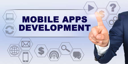 Business concept. Businessman touching virtual screen with his finger. Screen caption - MOBILE APPS DEVELOPMENTの写真素材