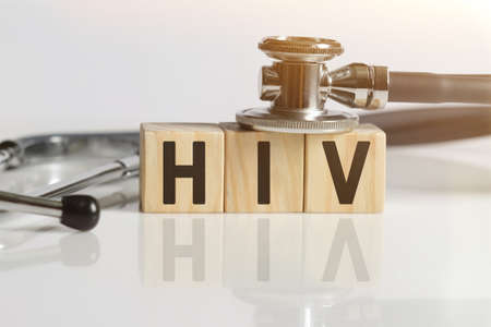 HIV the word on wooden cubes, cubes stand on a reflective white surface, on cubes - a stethoscope. Medicine conceptの写真素材