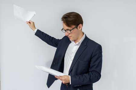 Businessman with scattered papers. Business, people, emotions - businessman throws documents in the office. Business and finance concept.の写真素材