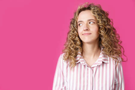 Young beautiful woman thinking looking to the side at blank copy space. Isolated pink backgroundの写真素材