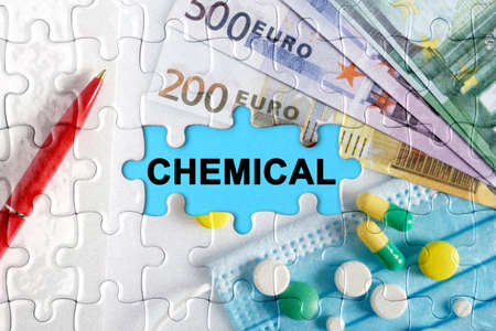 Double exposure. Puzzles with the image of pills, medical mask, pens and euro with the inscription -CHEMICAL. The concept of medicine.の写真素材