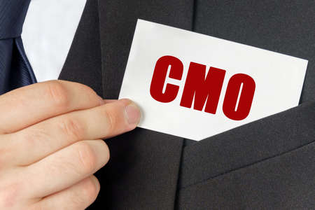Business concept. Businessman holds a card with the text - CMOの写真素材