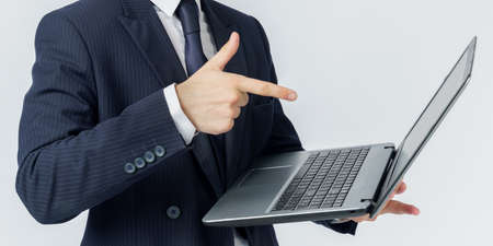 A businessman holds a laptop, the other hand shows the screen. White background. No face visible....